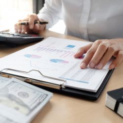 料金表を確認しながら電卓で計算しているビジネスパーソンの手元の画像