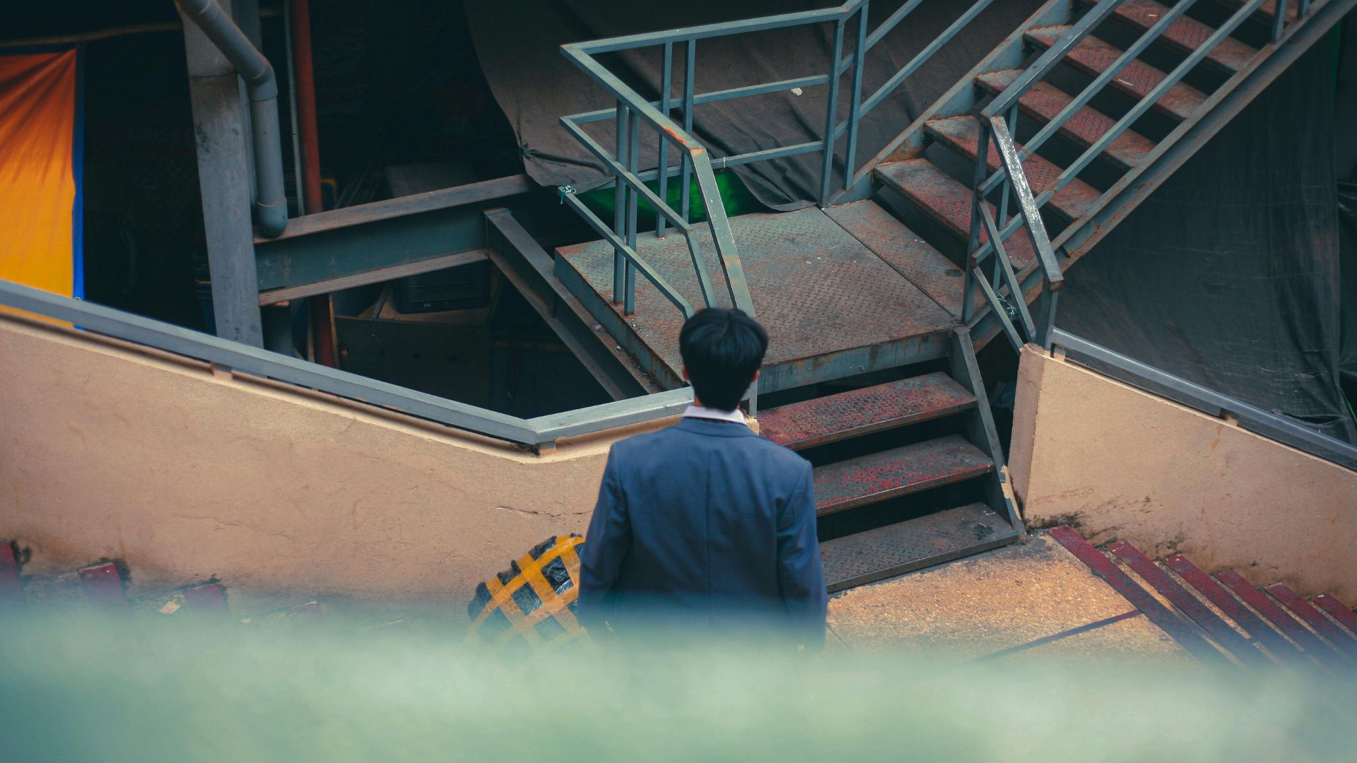 複雑に入り組んだ階段を前に立ち止まる男性の後ろ姿