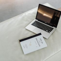 ノートパソコンと書籍が置かれたデスクの写真。オンライン学習や自己成長を象徴するイメージ。